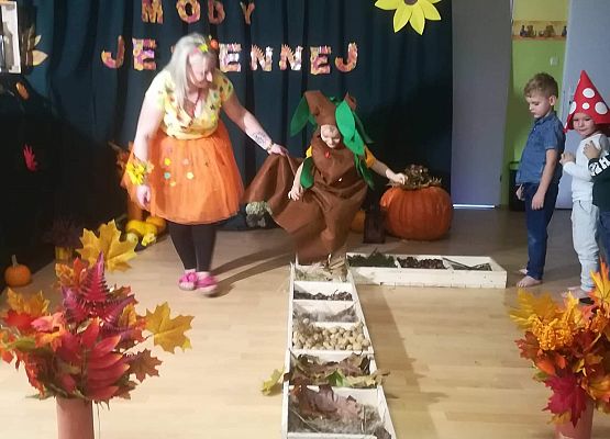 Chłopiec w asyście nauczycieli przechodzi przez ścieżkę sensoryczną