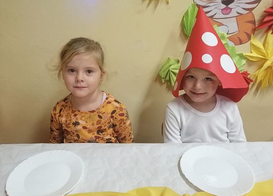 Chłopiec siedzi przy stole i czeka na słodki poczęstunek