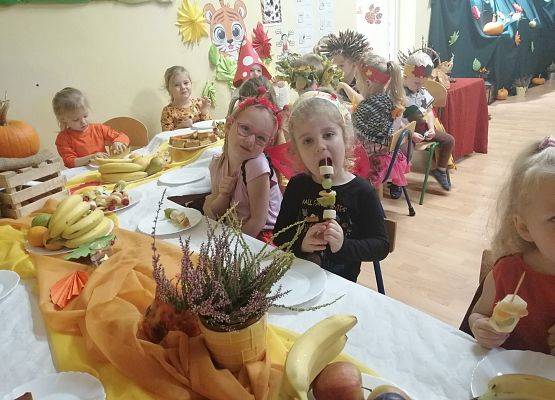Dzieci siedzą przy stole podczas słodkiego poczęstunku