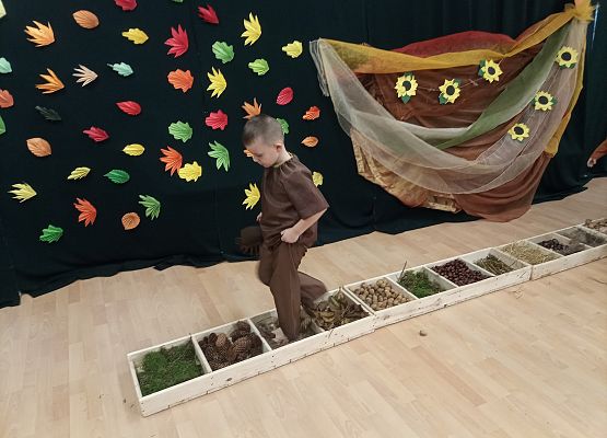 Chłopiec  przechodzi przez ścieżkę sensoryczną