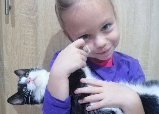 Dziewczynka przytula kota