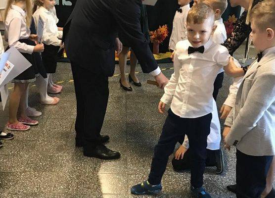 Dyrektor szkoły pasuje chłopca na ucznia Szkoły Podstawowej im. Jana Pawła II w Łebieniu.
