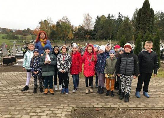 Zdjęcie grupowe uczniów z wychowawcą na cmentarzu