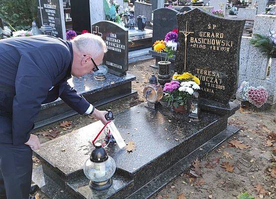 Dyrektor stawia na nagrobku znicz z napisem szkoła Pamięta