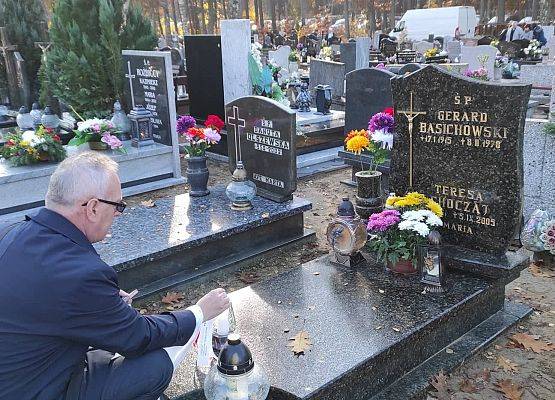 Dyrektor stawia na nagrobku znicz z napisem szkoła Pamięta