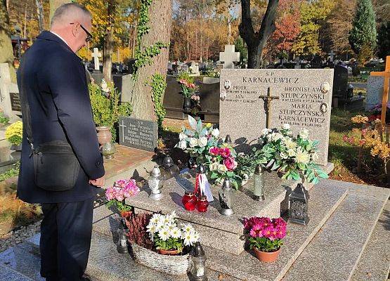 Dyrektor stoi przed nagrobkiem