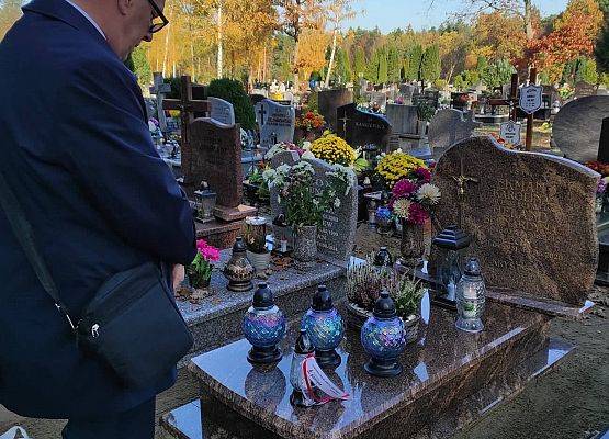 Dyrektor stoi przed nagrobkiem