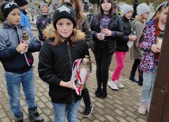 Uczniowie ze zniczami na cmentarzu w Łebieniu