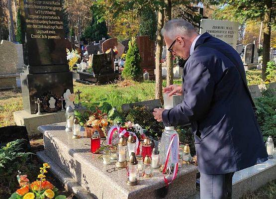 Dyrektor ustawia znicz z napisem Szkoła Pamięta