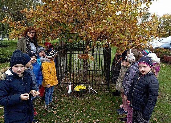 Grupa uczniów z wychowawcą przed "Dębem Katyńskim"