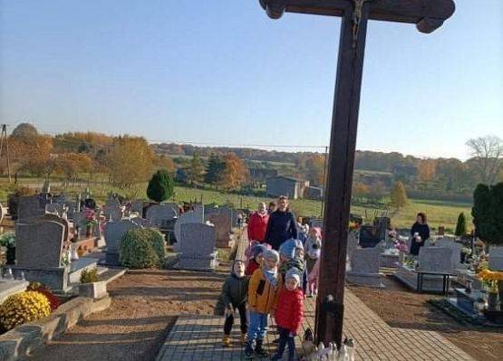 Przedszkolaki idą aleją na cmentarzu w Łebieniu