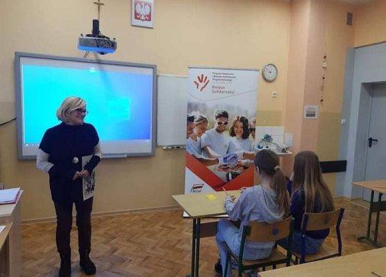 Trener prowadzący szkolenie rozmawia z wolontariuszami.