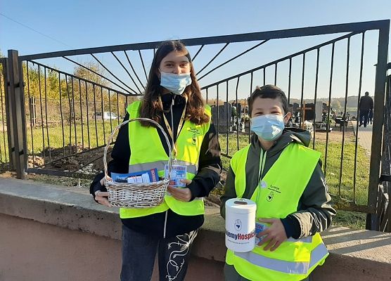 Wolontariusze przed bramą cmentarza w Łebieniu