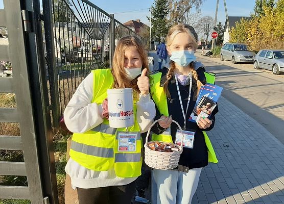 Dwie wolontariuszki stoją przy cmentarzu w Łebieniu