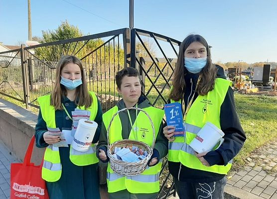 Wolontariusze przed bramą cmentarza w Łebieniu