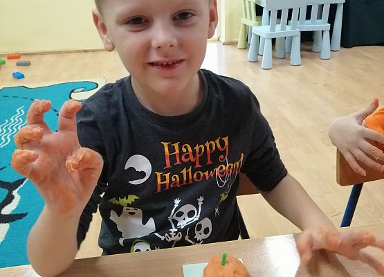 Chłopiec prezentuje wykonaną przez siebie dynię