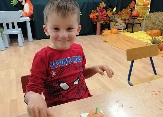 Chłopiec prezentuje wykonaną przez siebie dynię