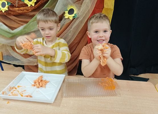 Dwaj chłopcy robią dynie z masy plastycznej