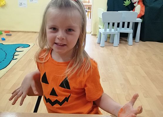 Dziewczynka  prezentuje wykonaną przez siebie dynię