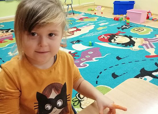 Dziewczynka  prezentuje wykonaną przez siebie dynię