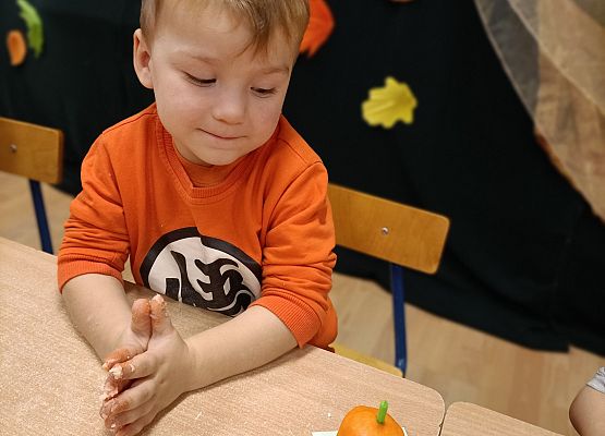 Chłopiec prezentuje wykonaną przez siebie dynię