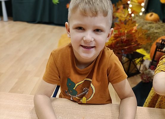 Chłopiec prezentuje wykonaną przez siebie dynię