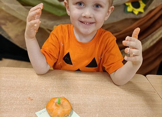Chłopiec prezentuje wykonaną przez siebie dynię