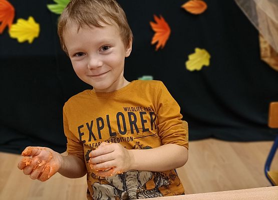 Chłopiec prezentuje wykonaną przez siebie dynię