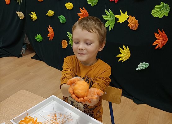 Chłopiec prezentuje wykonaną przez siebie dynię