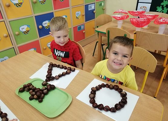 Chłopcy układają kasztany