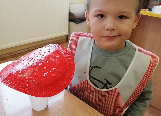 Chłopiec prezentyje wykonanego przez siebie muchomora