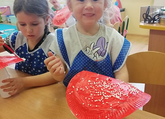 Dziewczynka prezentuje wykonanego przez siebie muchomora