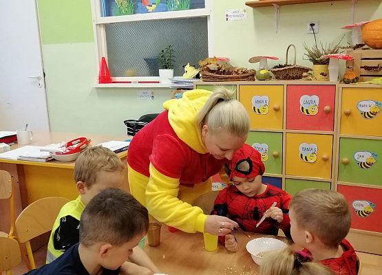 Nauczycielka pokazuje dzieciom, jak używać pęsety