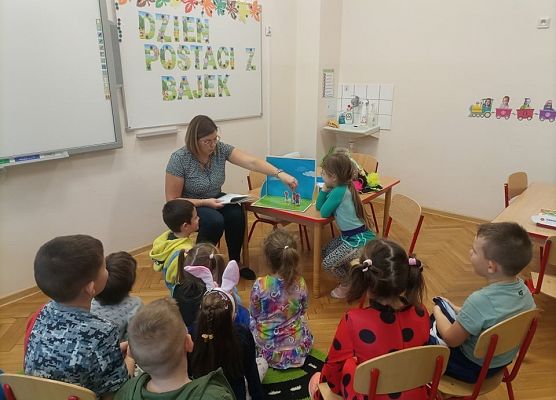 Nauczycielka czyta dzieciom bajkę z wykorzystaniem teatrzyku.