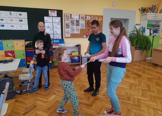 Przedstawiciel samorządu wręcza uczniowi zakładkę do książki