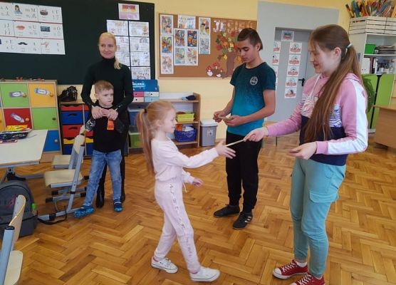 Przedstawiciel samorządu wręcza uczniowi zakładkę do książki