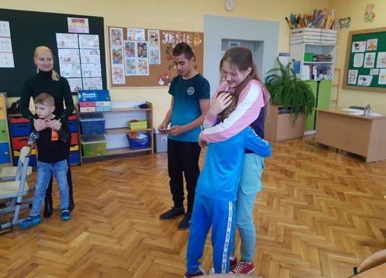 Przedstawiciel samorządu wręcza uczniowi zakładkę do książki