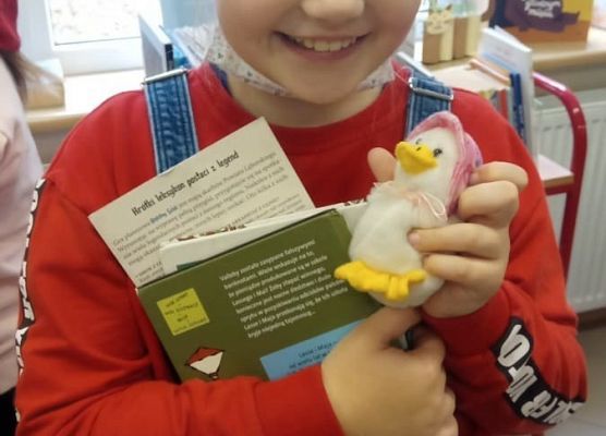 Uczennica trzyma ksiązki i bajkowy rekwizyt