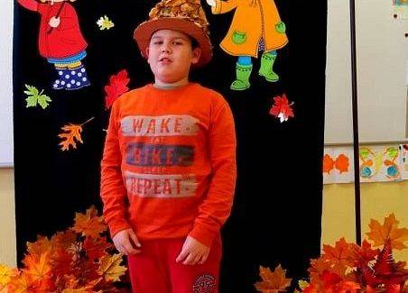 Uczeń stoi i recytuje wiersz o jesieni