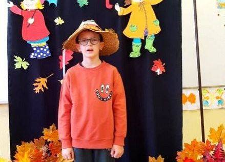 Uczeń stoi i recytuje wiersz o jesieni