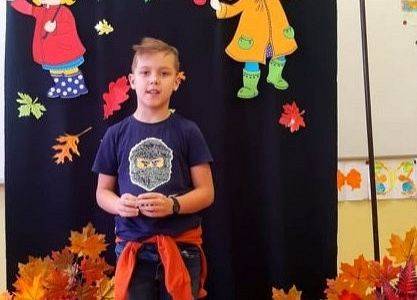 Uczeń stoi i recytuje wiersz o jesieni