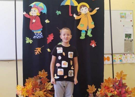 Uczeń stoi i recytuje wiersz o jesieni