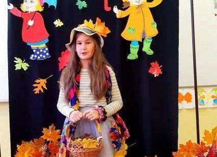 Uczennica stoi i recytuje wiersz o jesieni