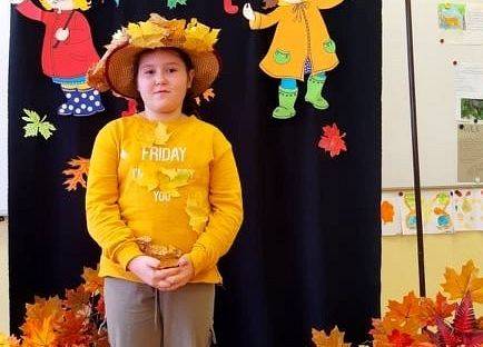 Uczennica stoi i recytuje wiersz o jesieni