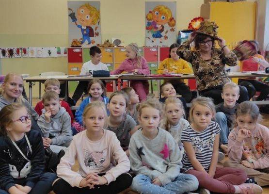 Uczniowie siedzą i słuchają wierszy