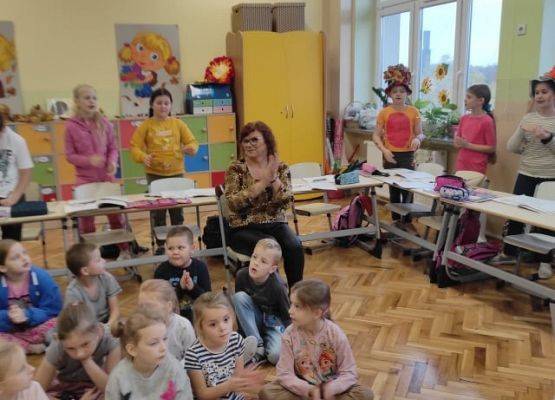 Uczniowie siedzą i słuchają wierszy