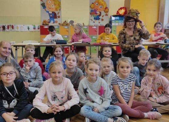 Uczniowie siedzą i słuchają wierszy