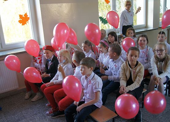 Dzieci siedzą podczas apelu i oglądają występy kolegów i koleżanek