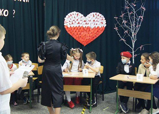 Grupy uczniów wykonujące konkurencyjne zadania na apelu