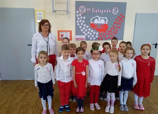 Uczniowie z nauczycielką śpiewają hymn